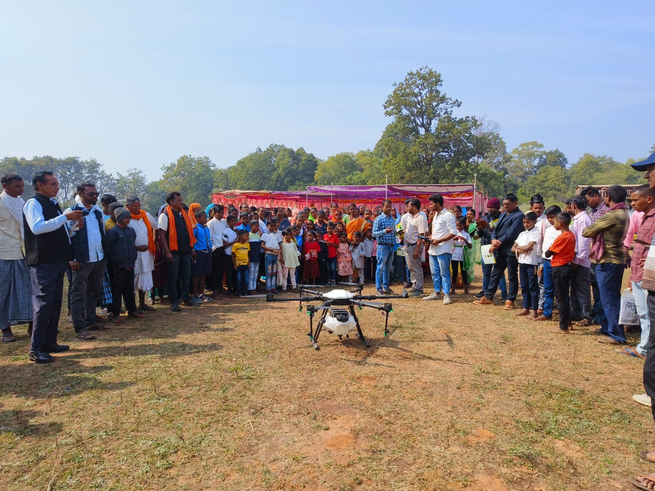 <em>विकसित भारत संकल्प यात्रा के तहत ग्रामीणों को बताया जा रहा ड्रोन कृषि का तरीका</em>